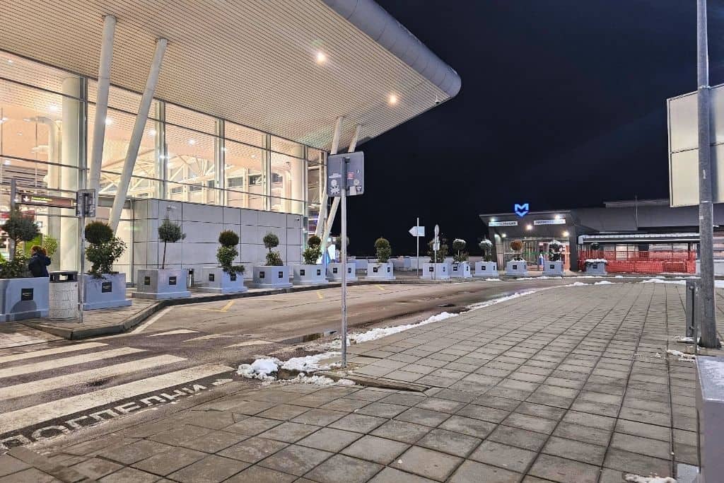 Exterior of Sofia Airport Terminal 2 at night with the metro station entrance visible, showing easy airport access to the city center — a top transport tip for new arrivals.